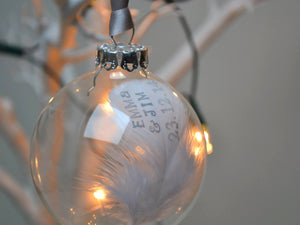 Hand stamped feather in a glass bauble